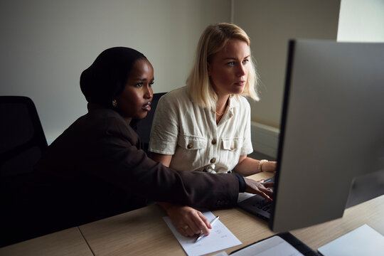 High angle view of focused female tech expert working on computer in office
