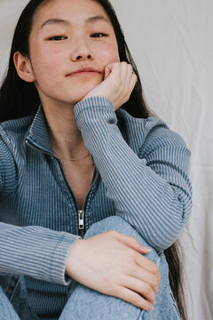 Portrait of beautiful young woman sitting while leaning on elbow