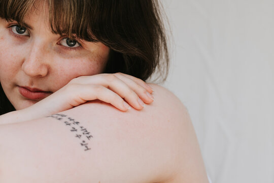 Close-up of beautiful young woman leaning on arm