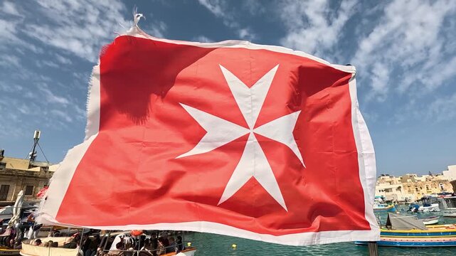 Maltese flag waves proudly on a pleasure boat during a sunny day, slow motion
