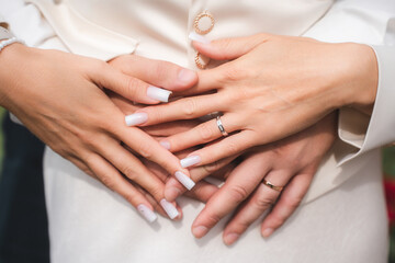 Fototapeta premium Couple's hands wearing engagement and wedding rings, symbolizing love, commitment, and marriage. A close-up view of joining hands