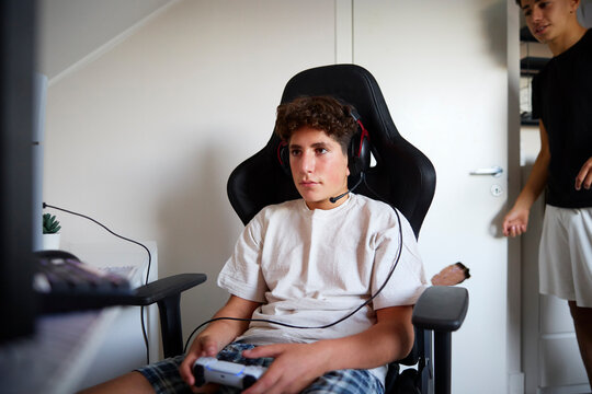 Boy spending leisure time playing video games at home