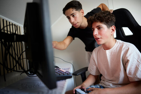 Curious brothers playing video games at home
