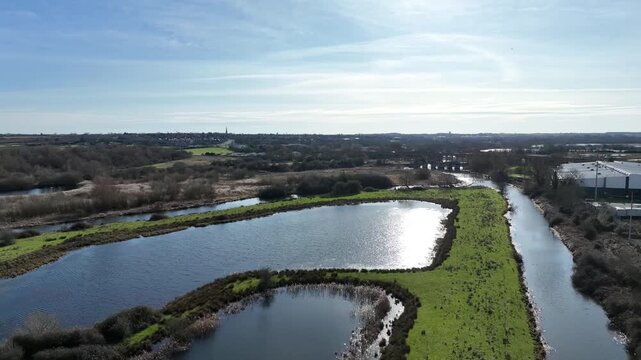 Aerial drone flight over River Nene and wetland pools along Nene Way on sunny day Northamptonshire