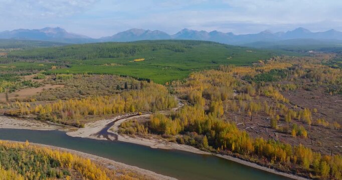 Wide, aerial drone descends on river confluence alluvial fan in floodplains, surrounding autumn landscape in northwest Montana
