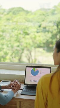 Analyzing data trends at home office person working on laptop indoor natural light close-up digital insight