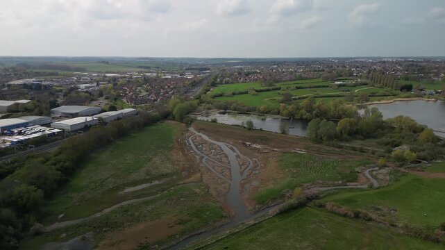 Wide aerial panorama of dried lake bed and Barton Seagrave village with surrounding countryside Northamptonshire