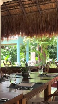 Outdoor Tropical Restaurant with Set Tables and Lush Greenery