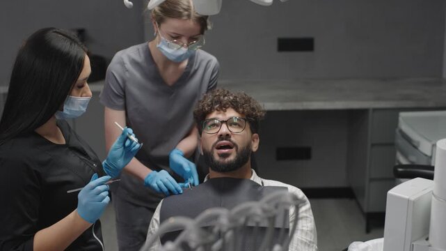 Dentist treats patient with dental procedure in clinic setting