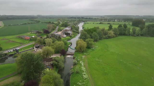 Aerial view of Barnwell Country Park river lock and green meadows with stone buildings Northamptonshire