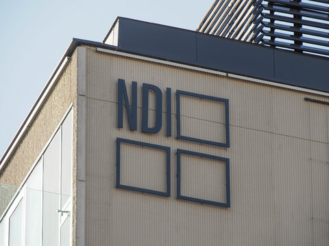 Close up of NDI company logo and signage on a modern office building facade