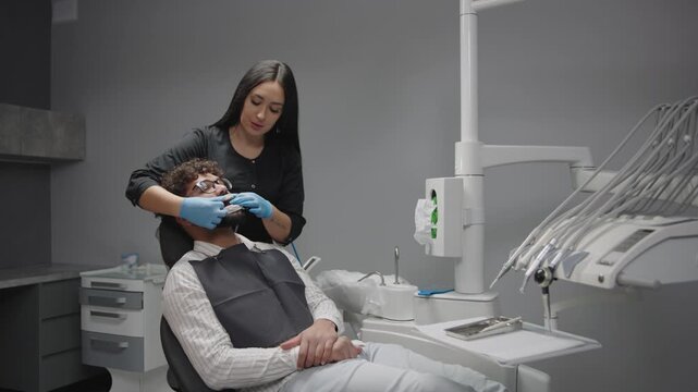 Dentist treats patient in a dental office with tools and equipment for oral care