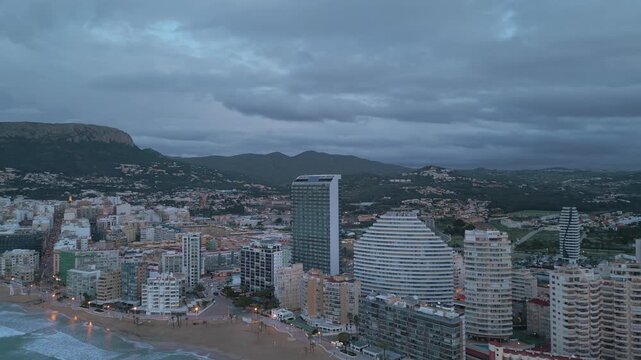 Aerial view of the Calpe coastline, with skyscrapers against a cloudy sky.