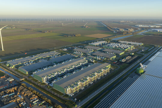 Aerial view of modern data center complex processing vast amounts of information, integrating technology with renewable wind energy in an agricultural area, Middenmeer, Netherlands.