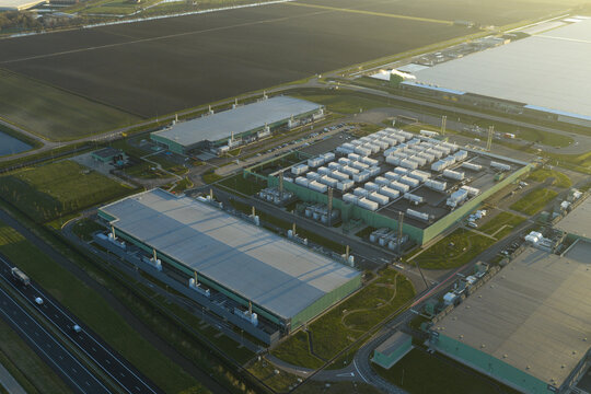 Aerial view of large interconnected ai data center complex with multiple buildings and storage units, handling internet and cloud computing operations, Middenmeer, Netherlands.