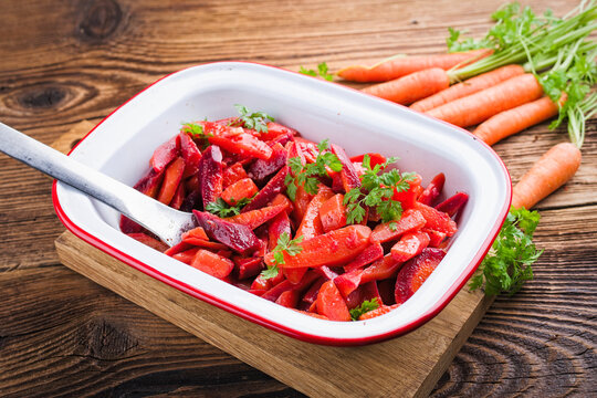 Easy homemade carrot salad with marinated carrots and beets serbed as close-up in a design bowl