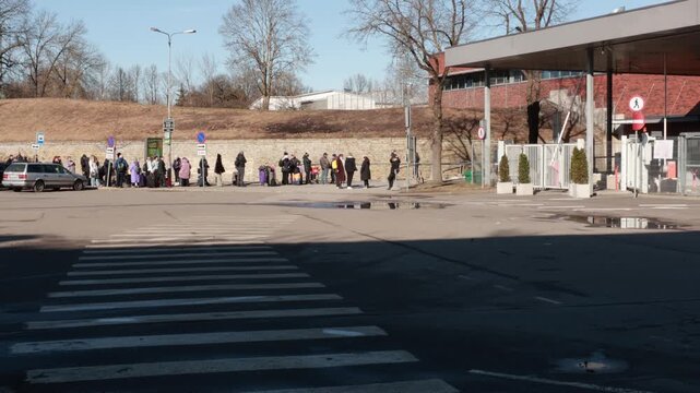 Narva, Estonia - March 2026: People waiting in line outdoors near checkpoint area. Everyday queue and travel situation.