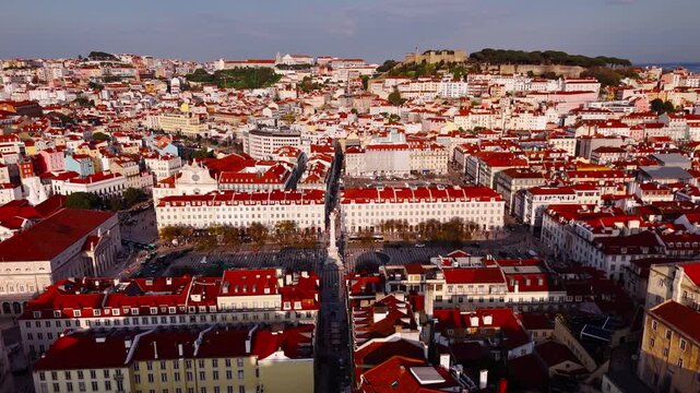 Establishing shot of Lisbon skyline with Rossio Square and Sao Jorge Castle at sunset