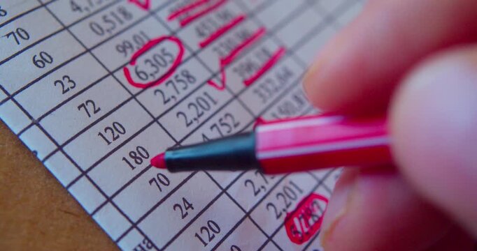 Paperwork.Close-up video of marker working with numbers on a paper sheet, illustrating business concept.