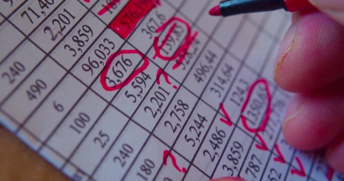 Paperwork.Close-up video of marker working with numbers on a paper sheet, illustrating business concept.