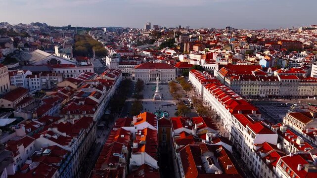 Establishing shot of Lisbon rooftops and Rossio Square at sunset golden hour