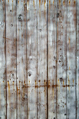 Vertical texture of weathered vintage wooden planks with faded white paint and rusty nails for rustic background design.