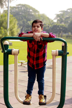 Elementary child exercising on single surfer pendel machine outdoor in nature.