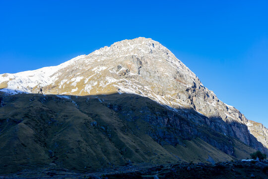 Sunlit Snow Capped Mountain Peak against Clear Blue Sky in Uttarakhand