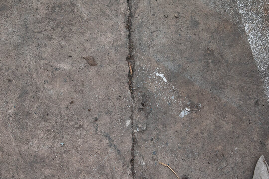 Imagen horizontal de un suelo de cemento con grietas y sucio ideal para texturas