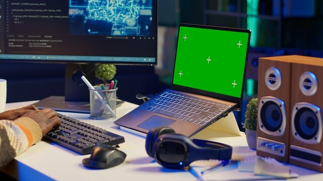 African american web developer using isolated mockup on pc and writing code