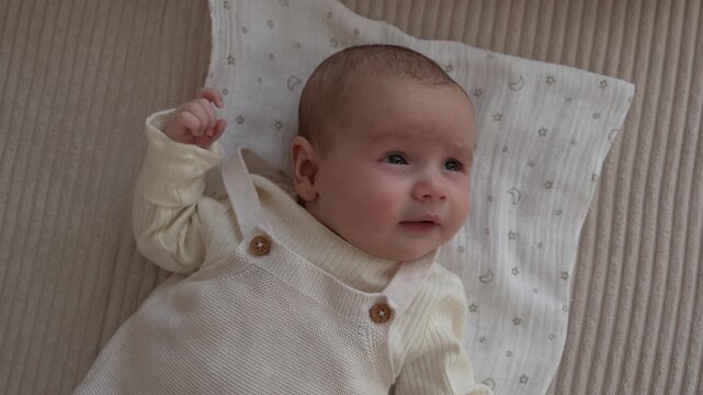 Close up of newborn baby lying on sofa and sneezing twice in a row in cozy home environment natural candid moment of infant health and reflex