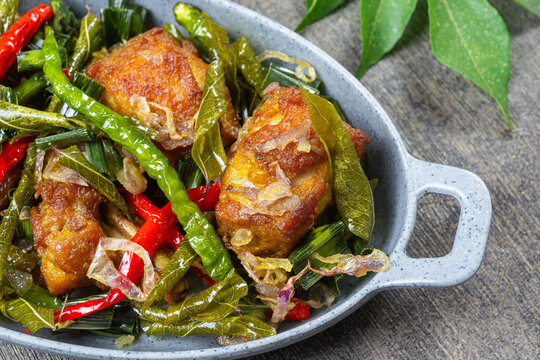 Ayam Tangkap,typical Aceh Indonesia culinary delights, Fried chicken cut into small pieces, cooked with rich spices, and served covered with curry leaves (temurui), pandan leaves, and green chilies on