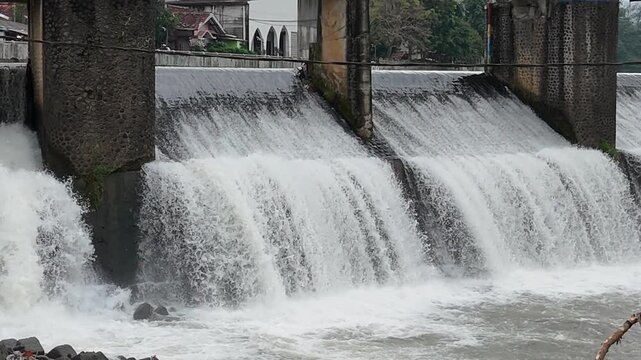 An aerial drone perspective reveals the historic Katulampa Dam spanning the Ciliwung River in Bogor