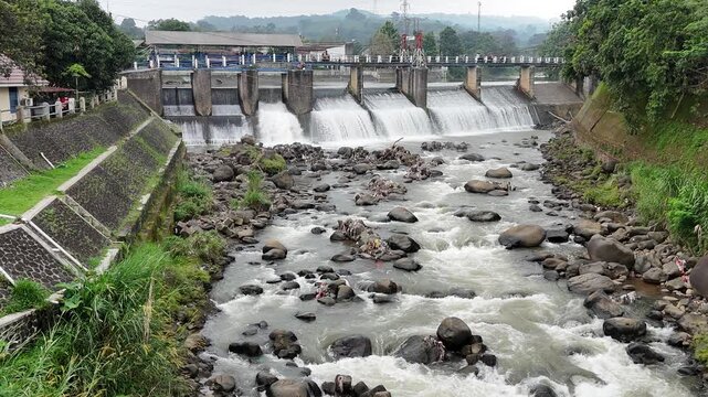 An aerial drone perspective reveals the historic Katulampa Dam spanning the Ciliwung River in Bogor