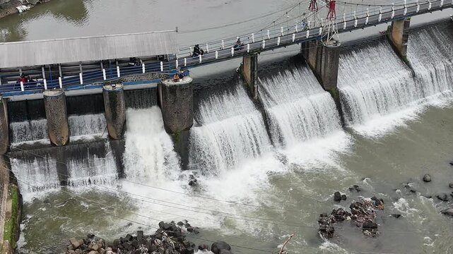 An aerial drone perspective reveals the historic Katulampa Dam spanning the Ciliwung River in Bogor
