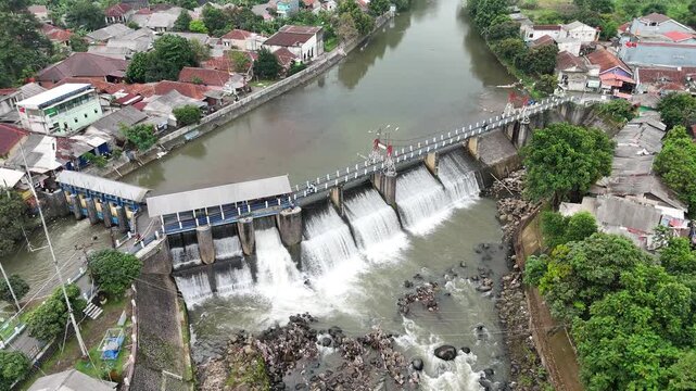 An aerial drone perspective reveals the historic Katulampa Dam spanning the Ciliwung River in Bogor