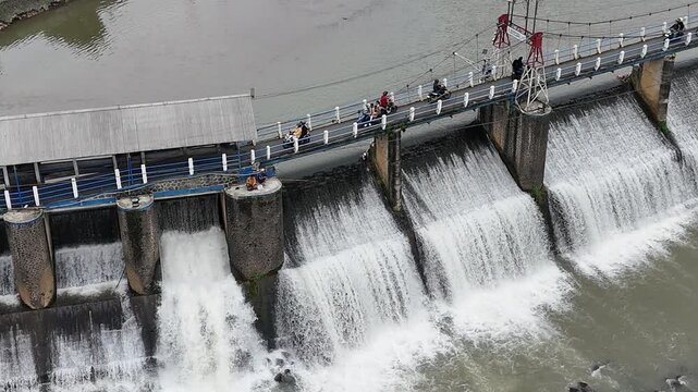 An aerial drone perspective reveals the historic Katulampa Dam spanning the Ciliwung River in Bogor