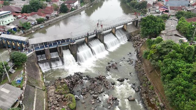 An aerial drone perspective reveals the historic Katulampa Dam spanning the Ciliwung River in Bogor