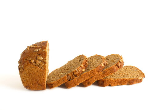 A sliced ​​loaf of black bread lies on a white background.