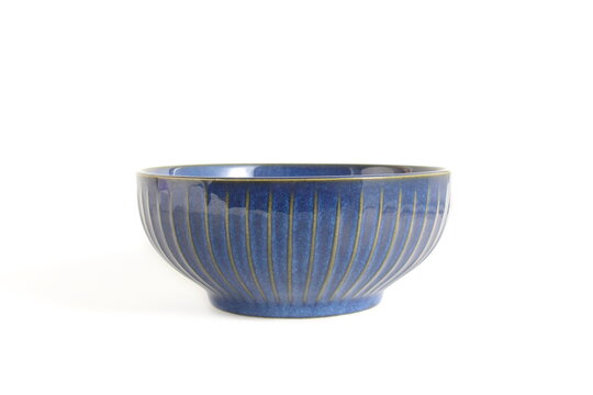 There is a blue ceramic plate on a white background.