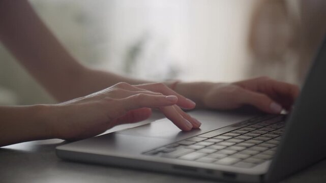 Hand Using Laptop Trackpad at Desk