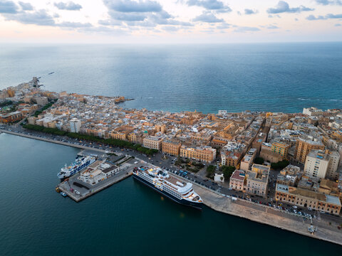 Aerial view of the historic harbor and city center with large ships docked at the pier in Trapani, Sicily, Italy.