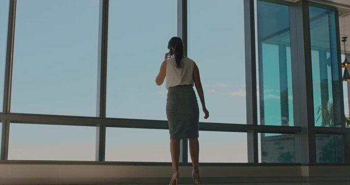 Window, talking and woman with phone call in hallway, consulting client and stocks investment discussion. Walking, trading advice and investor with mobile for economic update, low angle and space