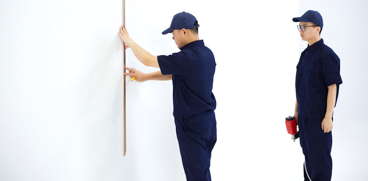 Two Asian workers are working in the empty space.