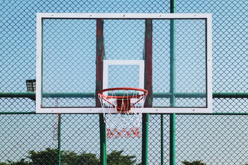 Outdoor street basketball hoop and net with clear sky background © Win Nondakowit