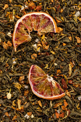 tea with added flavors and pieces of fruit and cut dried red oranges, bright large dry slices of blood red orange and green tea with pieces of fruit © rsooll