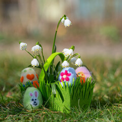 green basket with colorful felted eggs for easter party
