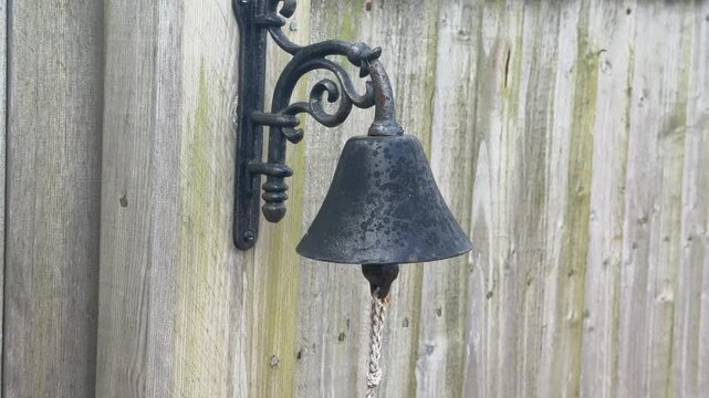 Antique iron bell hanging on fence panning