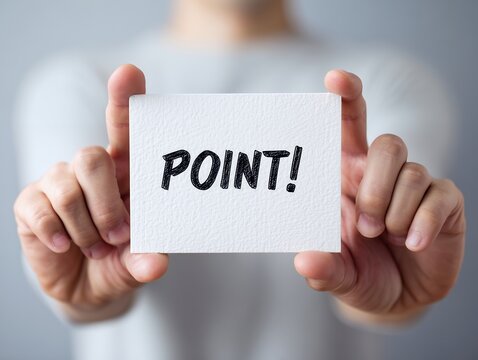 白いカードに黒い文字でPOINTと書かれた紙を両手で持って提示するグレーの服の男性
