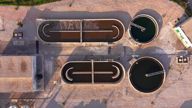Top-down view of wastewater treatment plant with clarifiers, aeration basins, sludge settling tanks, and hydraulic flow channels for biological and mechanical purification